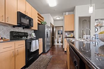 A kitchen with stainless steel appliances and wooden cabinets